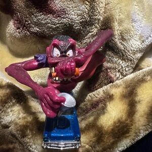 Purple Monster Figurine on Blue Car